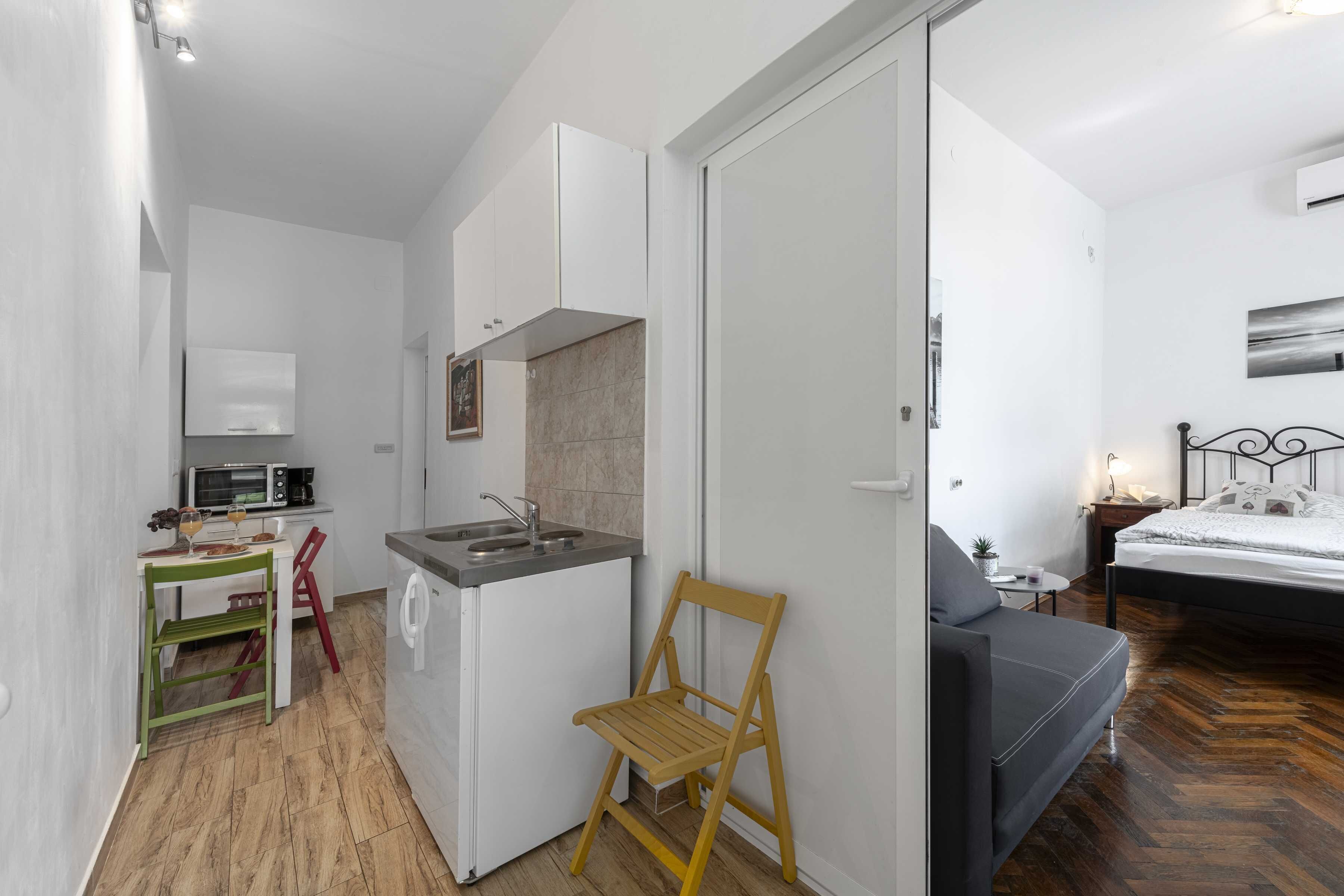 Una camera spaziosa con angolo cottura, un letto e una piccola zona relax.