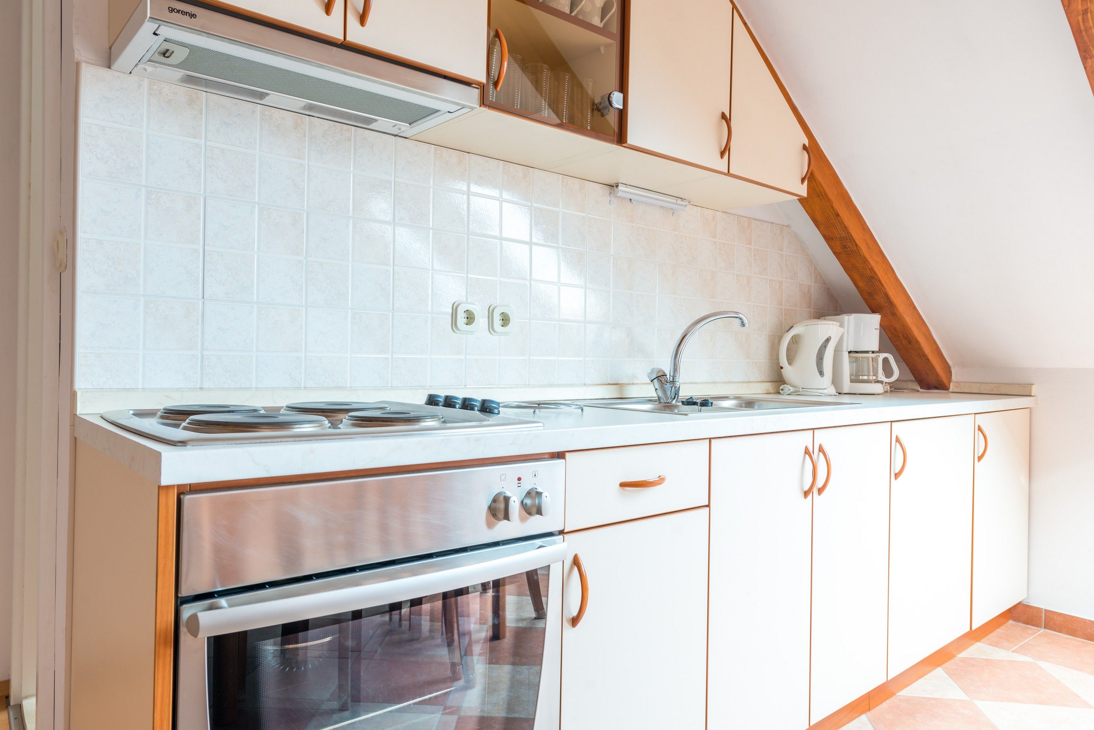 A kitchen with white cabinets, a stainless steel stove, and a tiled backsplash.