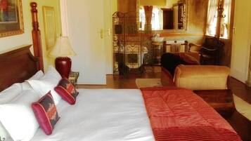 Una habitación de hotel con una cama, una silla, un escritorio y un espejo.