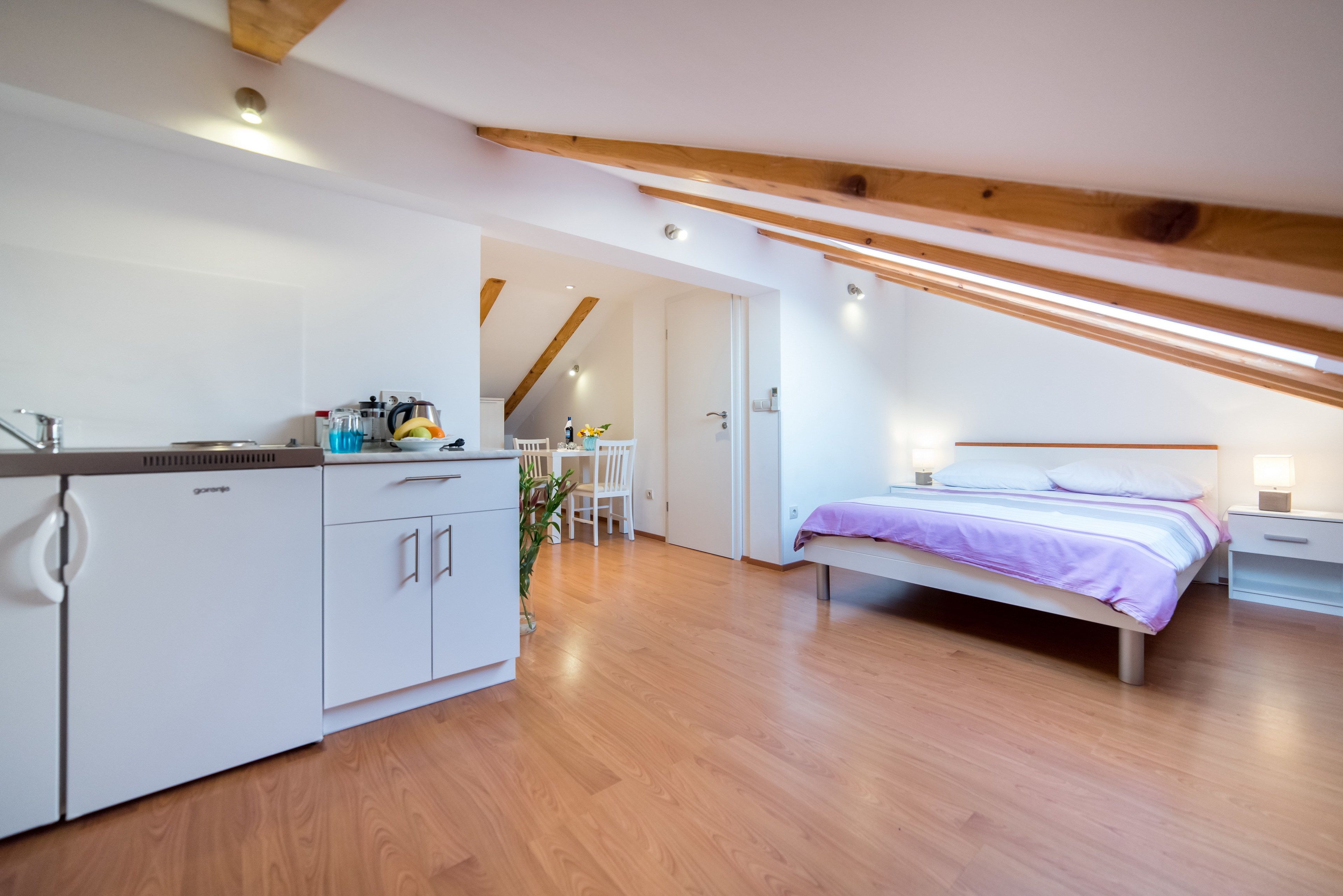 Ein modernes Schlafzimmer mit einem Bett, Nachttischen und einer kleinen Schreibtischzeile.