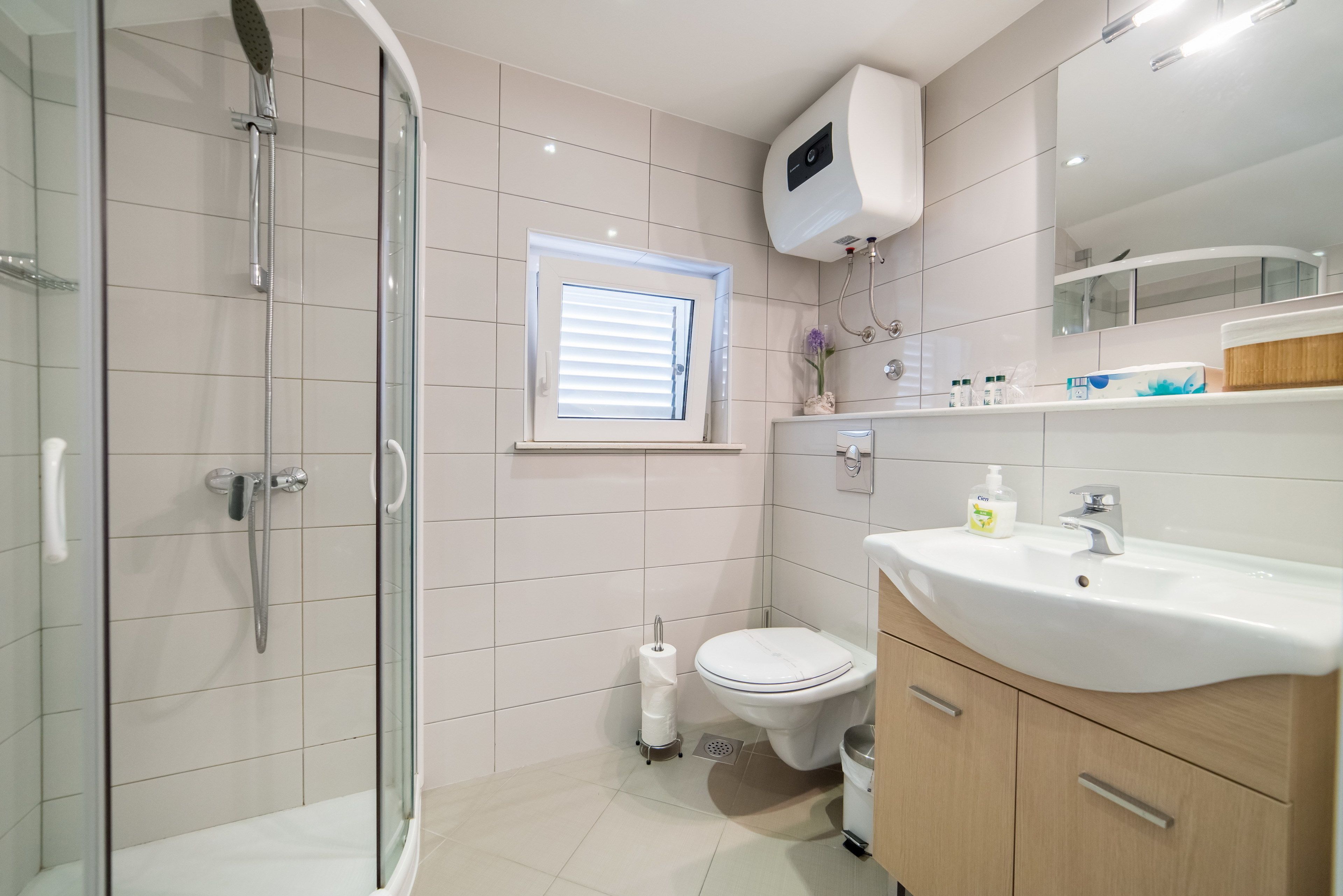 A modern bathroom with a glass-enclosed shower, a toilet, and a sink with a vanity.