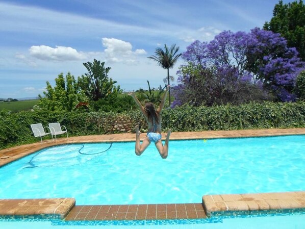 Alberca al aire libre y camastros 