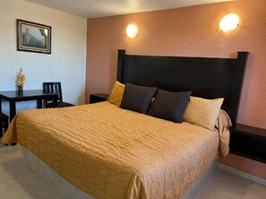 A bed with a headboard, two bedside tables, and a chair. - Hotel Posada Real (Mineral del Monte)