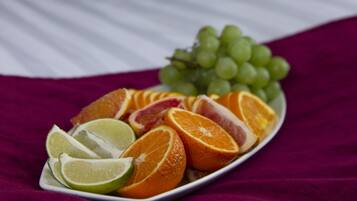 A bed with a white bedspread and a plate of fruit on it.