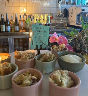 A bar area with a sign, various bottles, and a flower decoration. - Livin Station (Örebro)