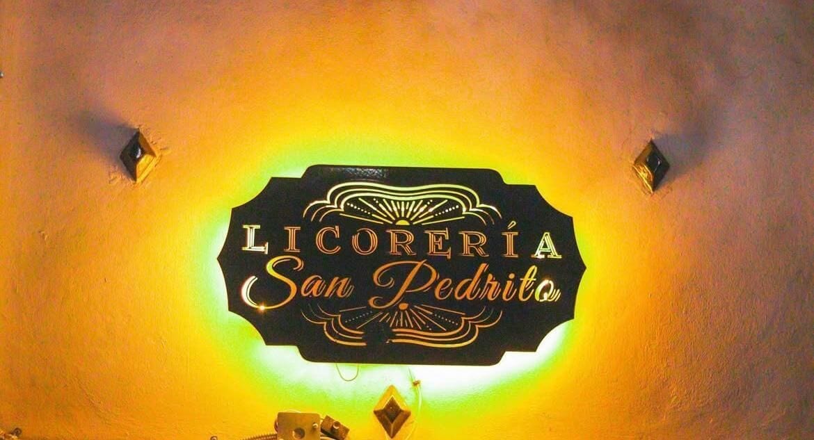A sign with the text "LICORERÍA San Pedrito" on a wall.