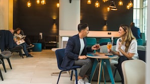 A modern indoor setting with seating areas, tables, and hanging pendant lights. - Apex City of Bath Hotel (Bath)