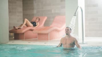 Una piscina techada, sillones reclinables de piscina