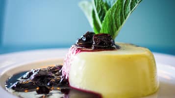 A dessert with a berry compote and mint garnish on a white plate.