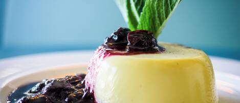 A dessert with a berry compote and mint garnish on a white plate.