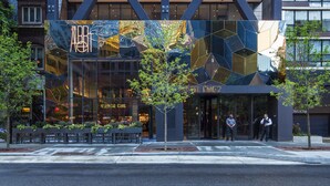A modern hotel with a blue facade, large windows, and a prominent entrance. - Hotel EMC2, Autograph Collection (Chicago)