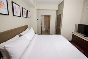 A hotel room with a large bed, a TV, and framed artwork on the wall. - Hilton Garden Inn Tampa Suncoast Parkway (Lutz)