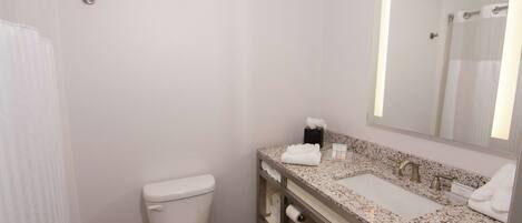 A bathroom with a toilet, sink, and mirror.