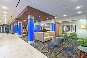 A hotel lobby with a seating area, a reception desk, and a large window. - Holiday Inn Express & Suites Brenham South by IHG (Brenham)