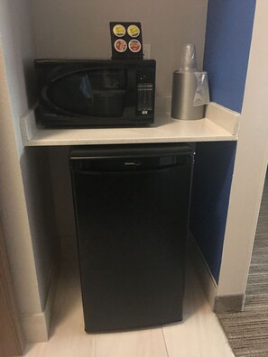 A compact kitchenette with a black microwave, a small refrigerator, and a coffee maker on the counter. - Holiday Inn Express & Suites Brenham South by IHG (Brenham)