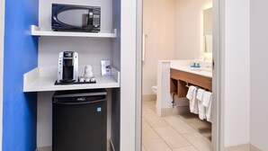 Una kitchenette compacta con microondas, cafetera y lavavajillas.
