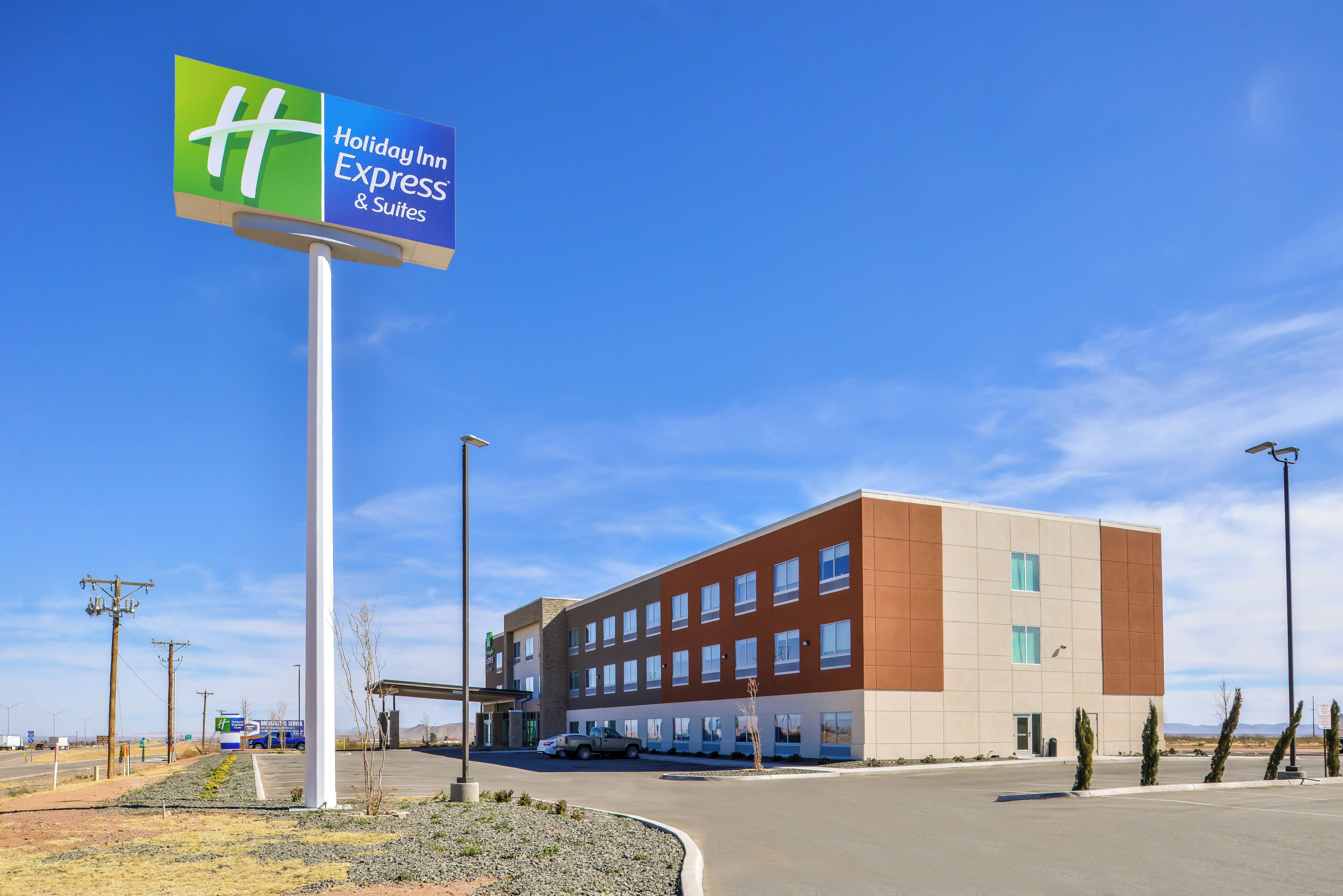 A Holiday Inn Express & Suites building with a clear sky.