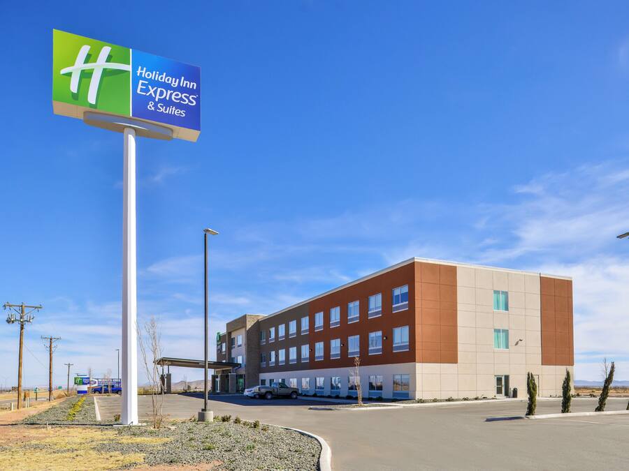 A Holiday Inn Express & Suites building with a clear sky.