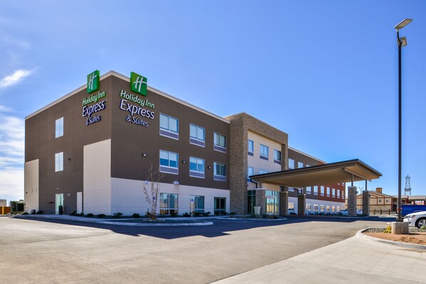 A Holiday Inn Express building with a covered entrance and a clear sky.