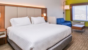 Una habitación de hotel con una cama grande, un escritorio, una silla y una ventana.