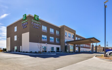 A Holiday Inn Express & Suites hotel with a modern design, featuring a covered entrance and multiple windows.