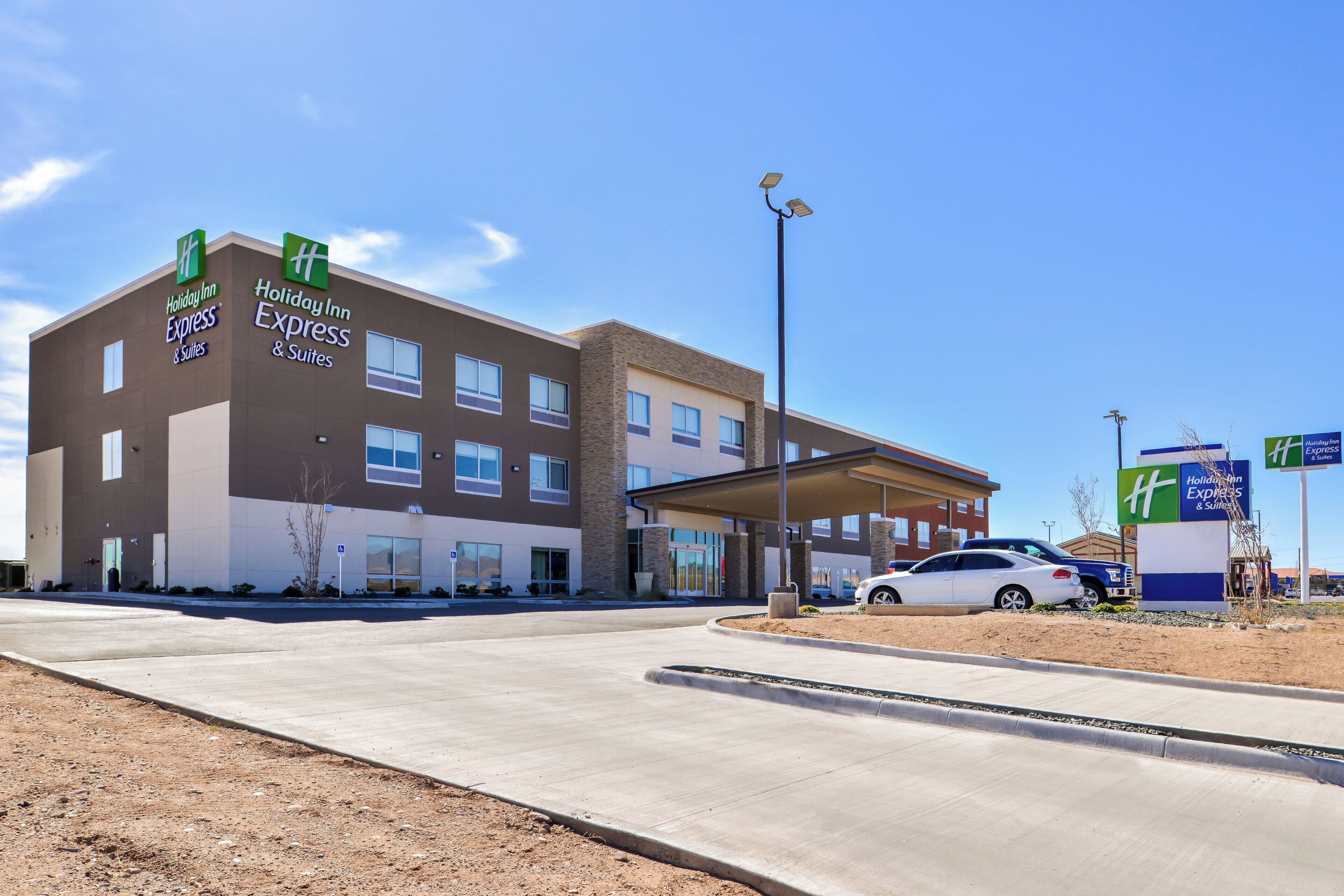 Un hôtel Holiday Inn Express & Suites au design moderne, doté d’une entrée couverte et d’un parking.