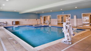 An indoor swimming pool with a lifeguard chair, a changing room, and a reception area. - Holiday Inn Express & Suites Parkersburg East by IHG (Parkersburg)