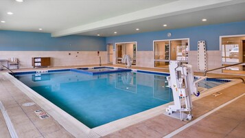 Piscina interna com cadeira de salva-vidas, sala de trocas e área de recepção.