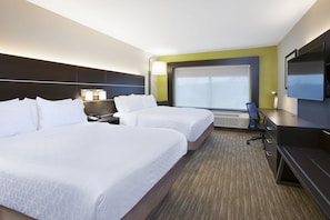 Habitación de hotel con dos camas, un escritorio, una silla, un televisor y un ventanal grande.