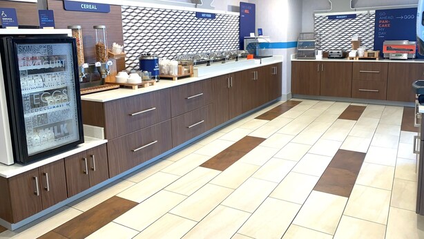 A breakfast area with a refrigerated display of dairy products, a counter for hot food, and a bakery section. - Holiday Inn Express & Suites Parkersburg East by IHG (Parkersburg)