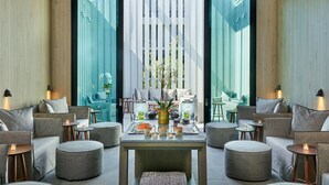 A modern interior with a central table, seating arrangements, and large windows. - Alila Napa Valley, a Hyatt Luxury Resort (St. Helena)