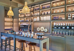 A well-organized retail space with shelves stocked with various products, a central display table with numbered jars, and hanging pendant lights. - Alila Napa Valley, a Hyatt Luxury Resort (St. Helena)