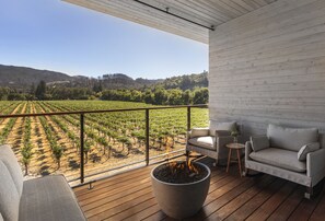 A balcony with a view of a vineyard, a fire pit, and a sofa. - Alila Napa Valley, a Hyatt Luxury Resort (St. Helena)