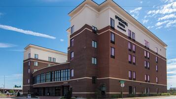 A multi-story hotel with a modern design, featuring a prominent entrance with a glass facade and a brick exterior.