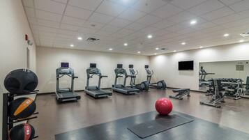 A gym with treadmills, exercise balls, and weight machines.