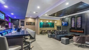 A modern bar area with seating and a fireplace. - SpringHill Suites by Marriott Oklahoma City Downtown (Oklahoma City)