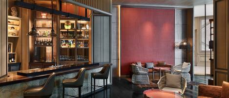 A modern bar area with a marble countertop, bar stools, and a well-stocked liquor cabinet.