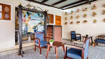 A room with patterned floor tiles, a mural with a swan, and multiple chairs.