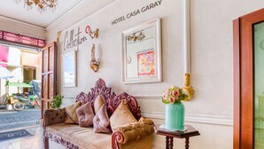 A lobby with a sofa, a vase with flowers, and a sign reading "HOTEL CASA GARAY". - Hotel Boutique Casa Garay (Oaxaca)