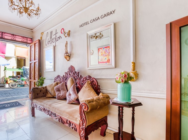 A lobby with a sofa, a vase with flowers, and a sign reading "HOTEL CASA GARAY". - Hotel Boutique Casa Garay (Oaxaca)