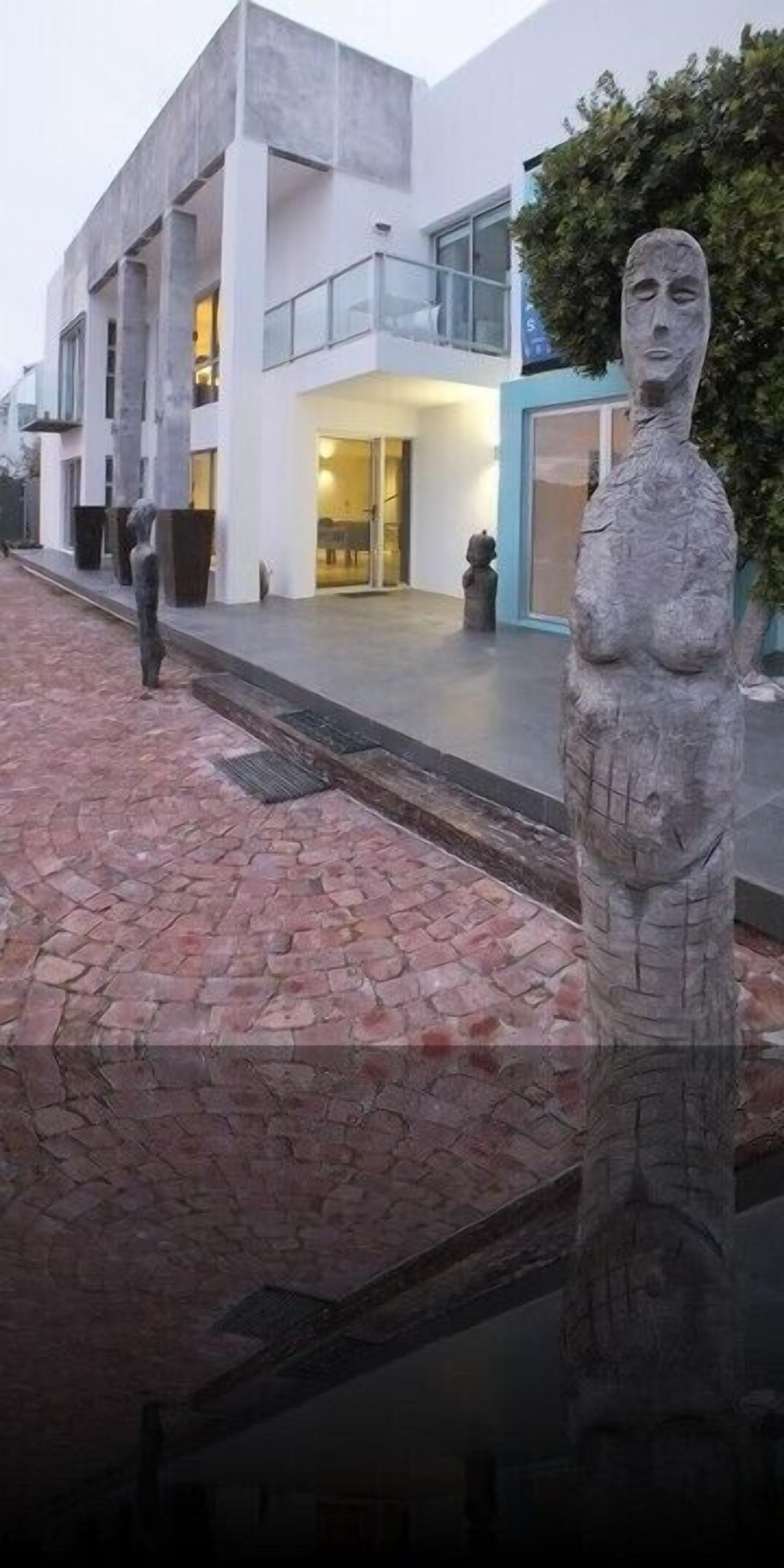 A modern building with a stone statue in the foreground.