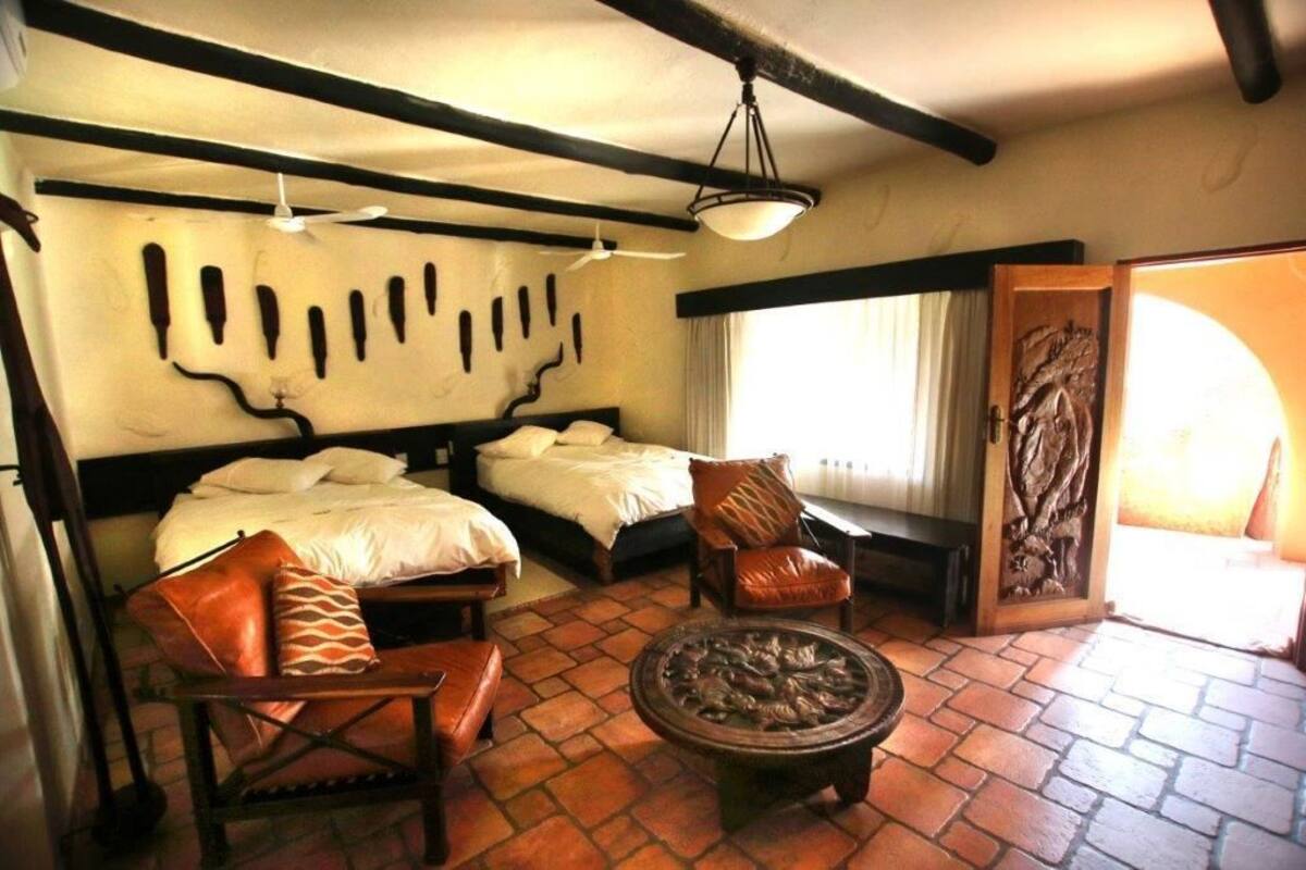 Habitación con dos camas, un sofá, una mesita de centro y una decoración de pared.