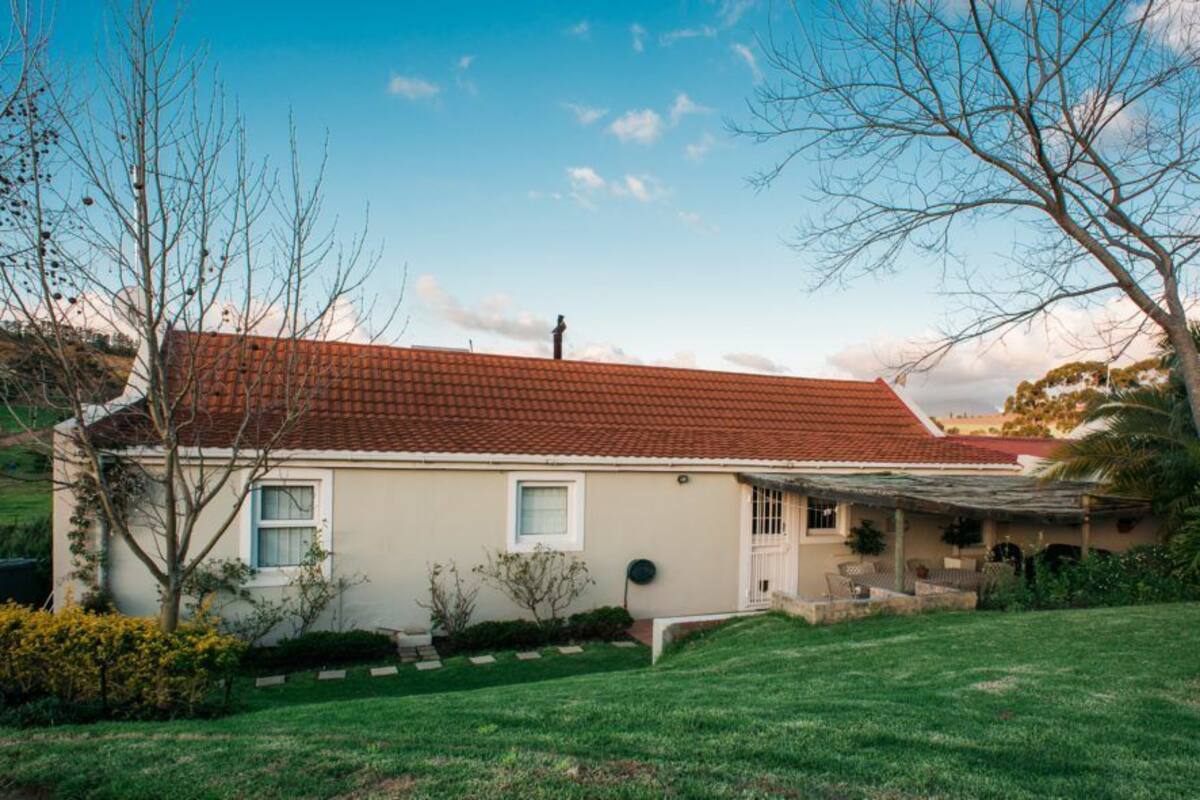 A single-story house with a red-tiled roof, a front porch, and a well-maintained lawn.