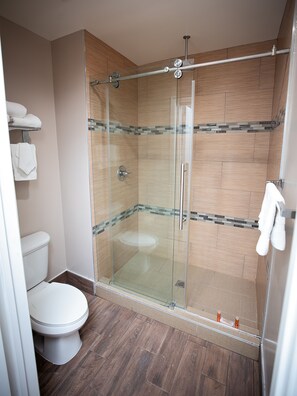 A modern bathroom with a glass-enclosed shower, a toilet, and a sink. - Diamond Bell Inn & Suites (Bell Gardens)