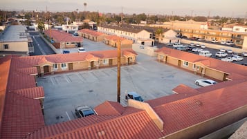 A parking lot with several buildings, including a motel with red-tiled roofs and a visible sign.