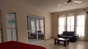 A room with a bed, a sofa, a coffee table, and a ceiling fan. - Hotel Guivá San Pablo (Oaxaca)
