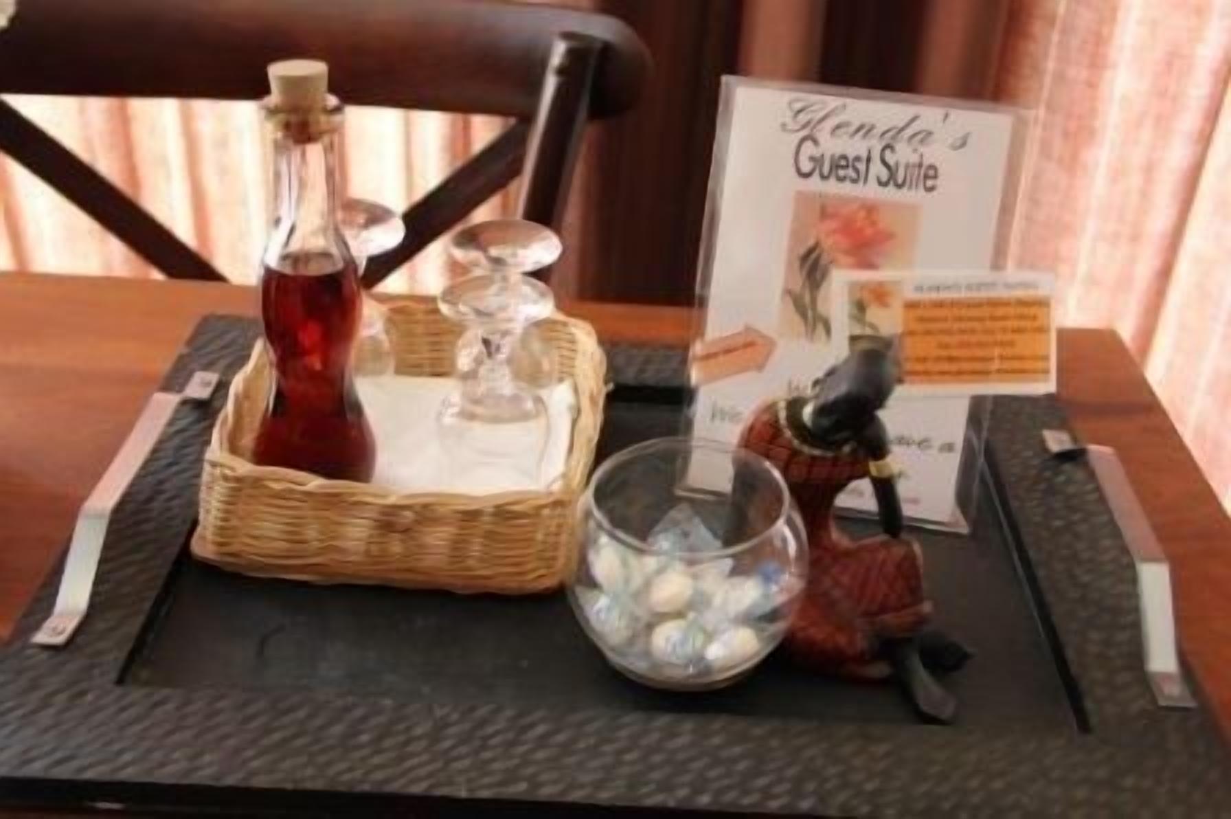 A table with a bottle, a basket, a glass, and a figurine.