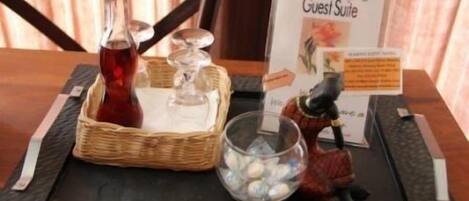A table with a bottle, a basket, a glass, and a figurine.