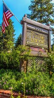 A wooden sign with "The Lodge" and "Vacation Ownership" text, a number "3840", and a "No Vacancy" sign below.