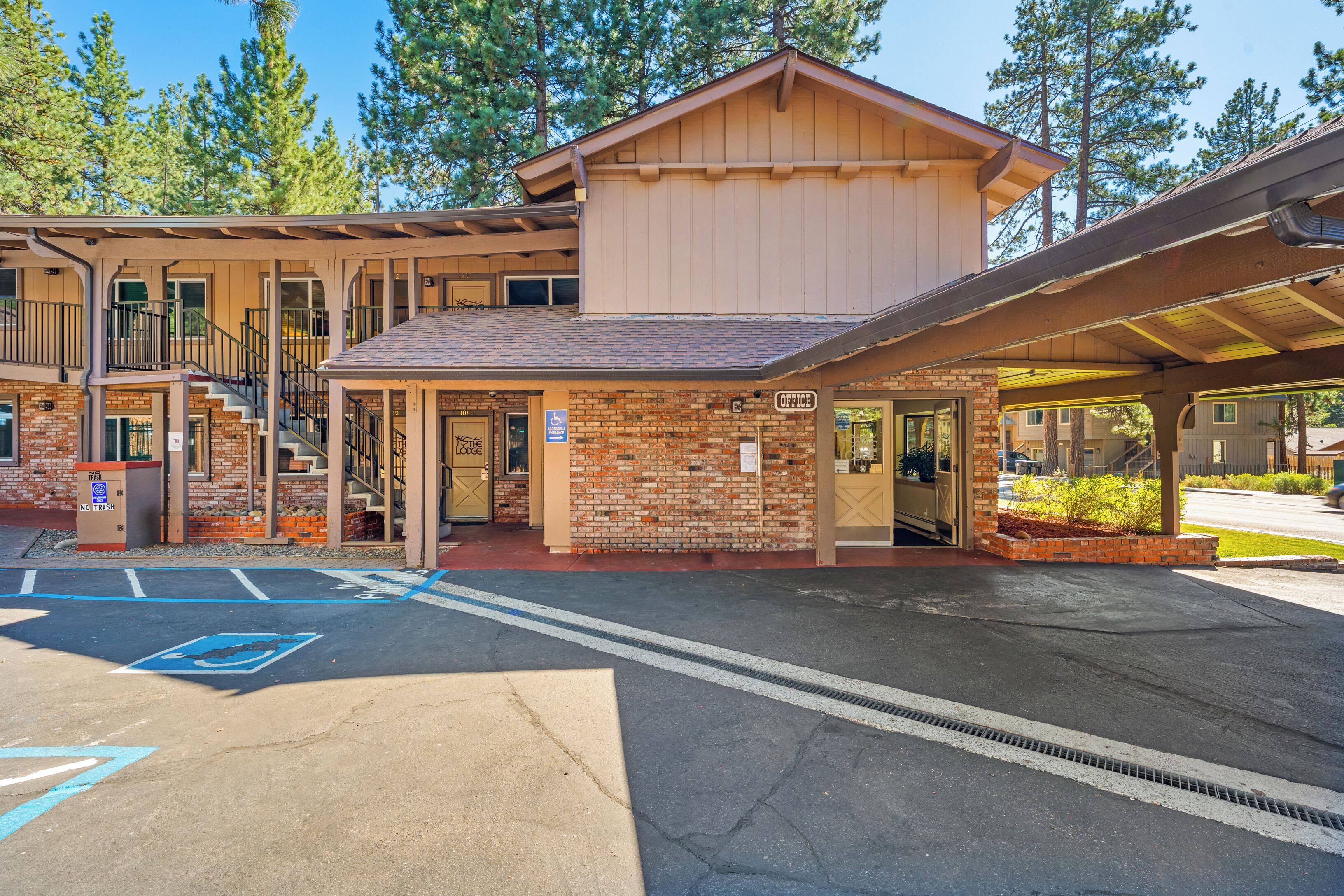 A lodge with a brick facade, a covered entrance, and a parking area with handicapped accessibility.